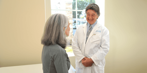 Doctor smiling at a patient in an exam room.