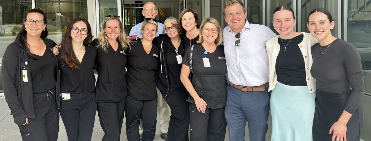 A group of people standing in front of a medical office building.