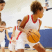 Women playing basketball on an indoor court.